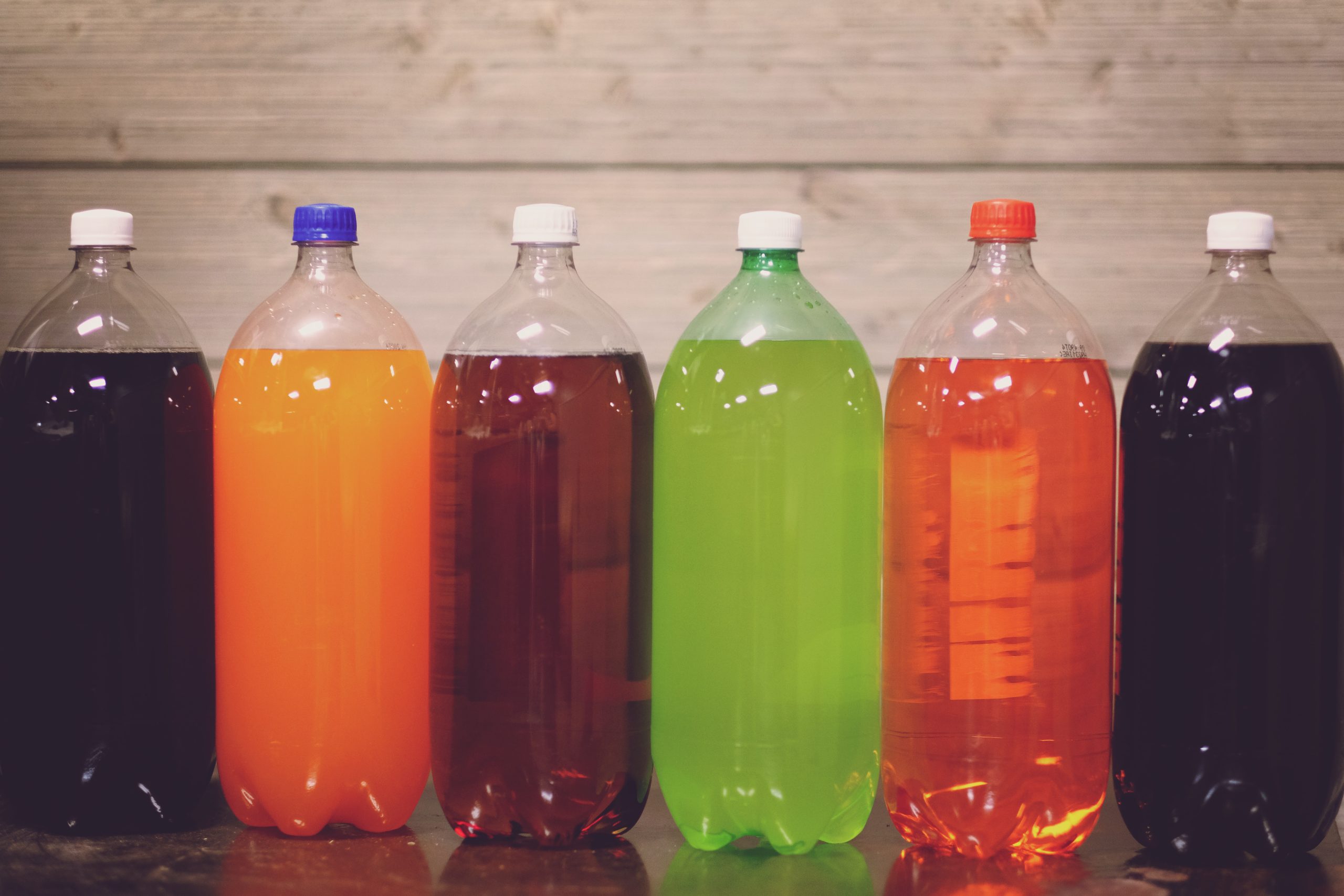 Seis botellas de plástico con líquido de colores variados